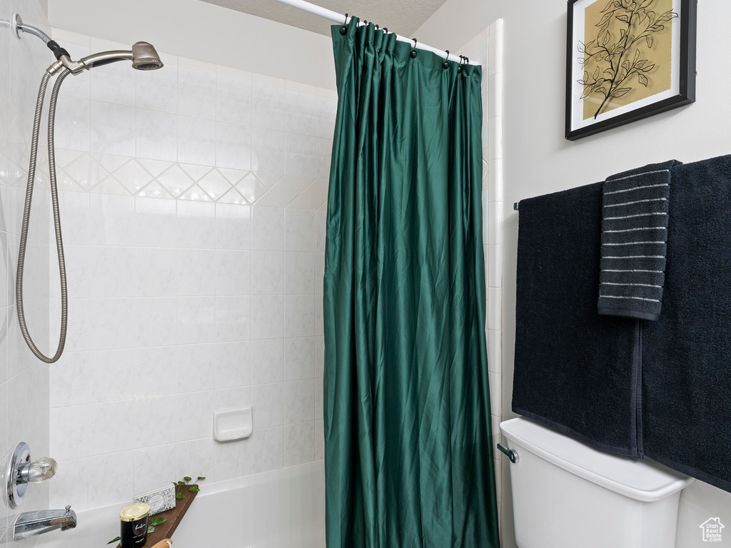 Bathroom with shower / tub combo with curtain and toilet