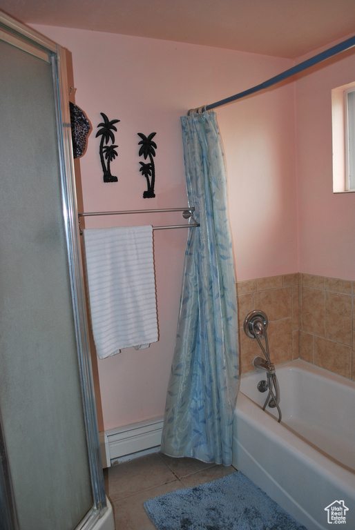 Bathroom with tile floors, baseboard heating, and a bath