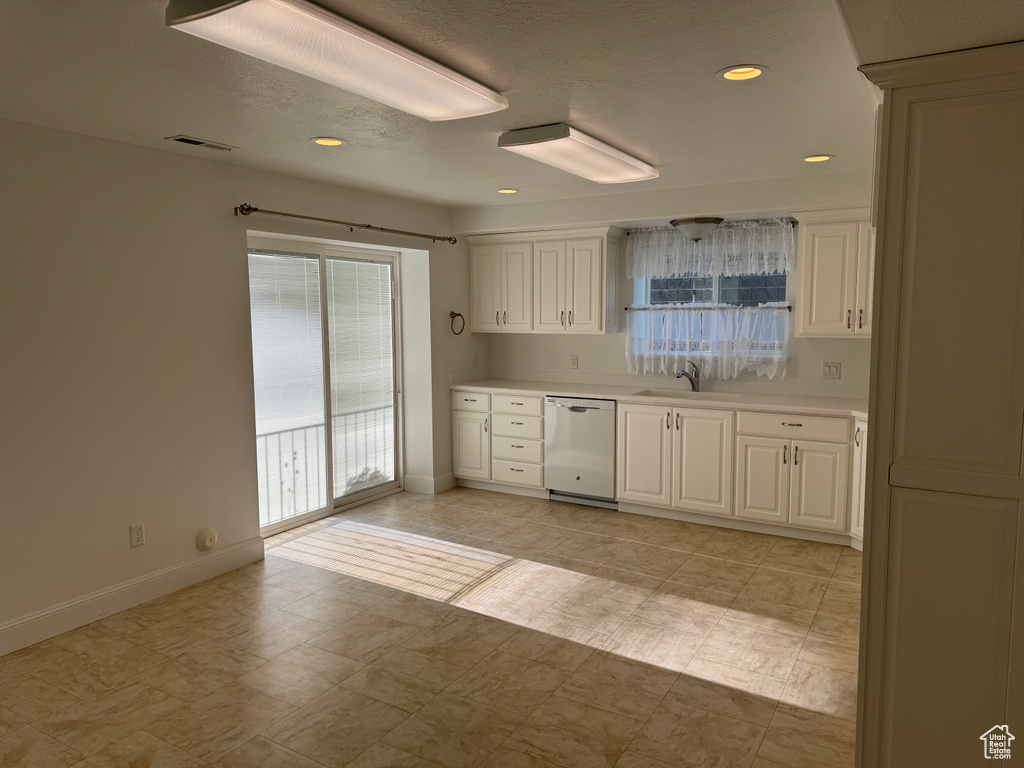 Kitchen with plenty of natural light, dishwasher, and light tile floors