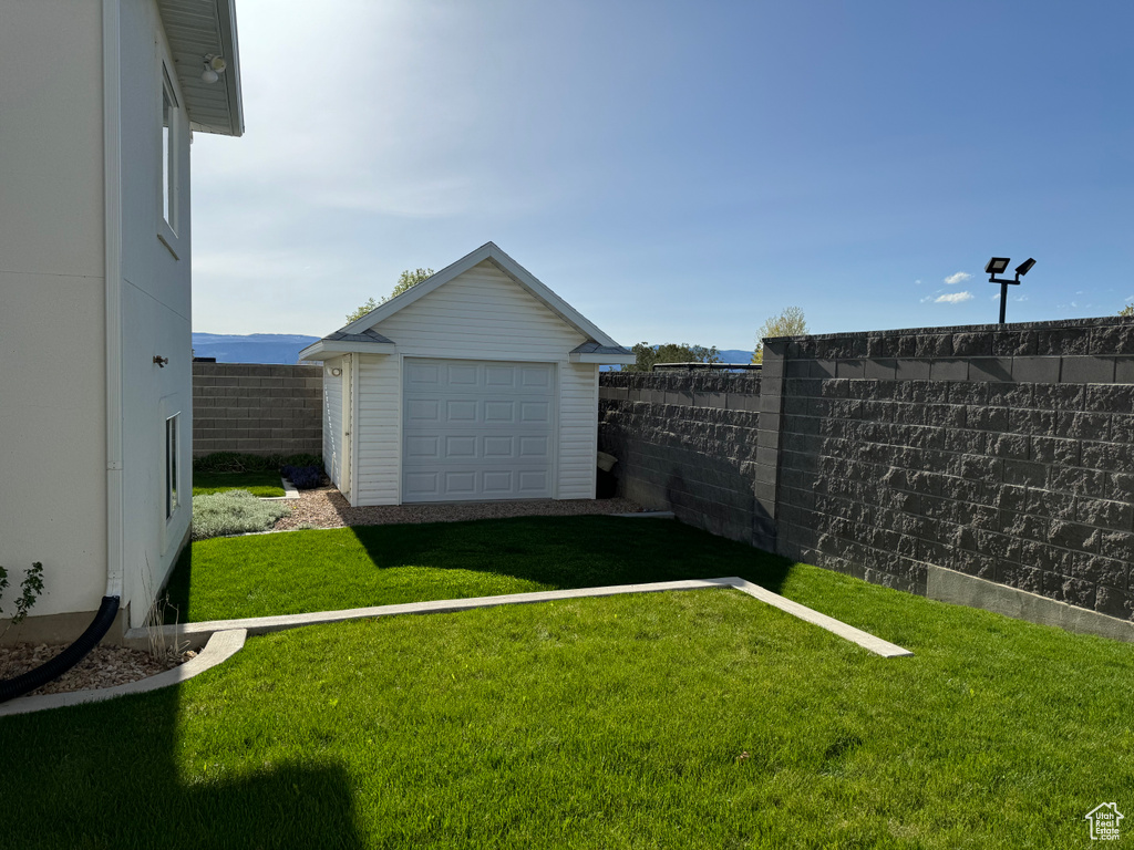 View of yard featuring a garage and an outdoor structure