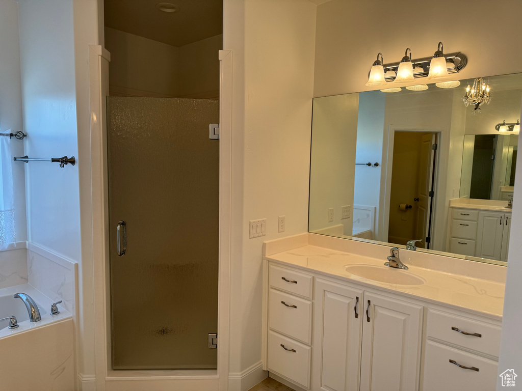 Bathroom featuring independent shower and bath and vanity with extensive cabinet space