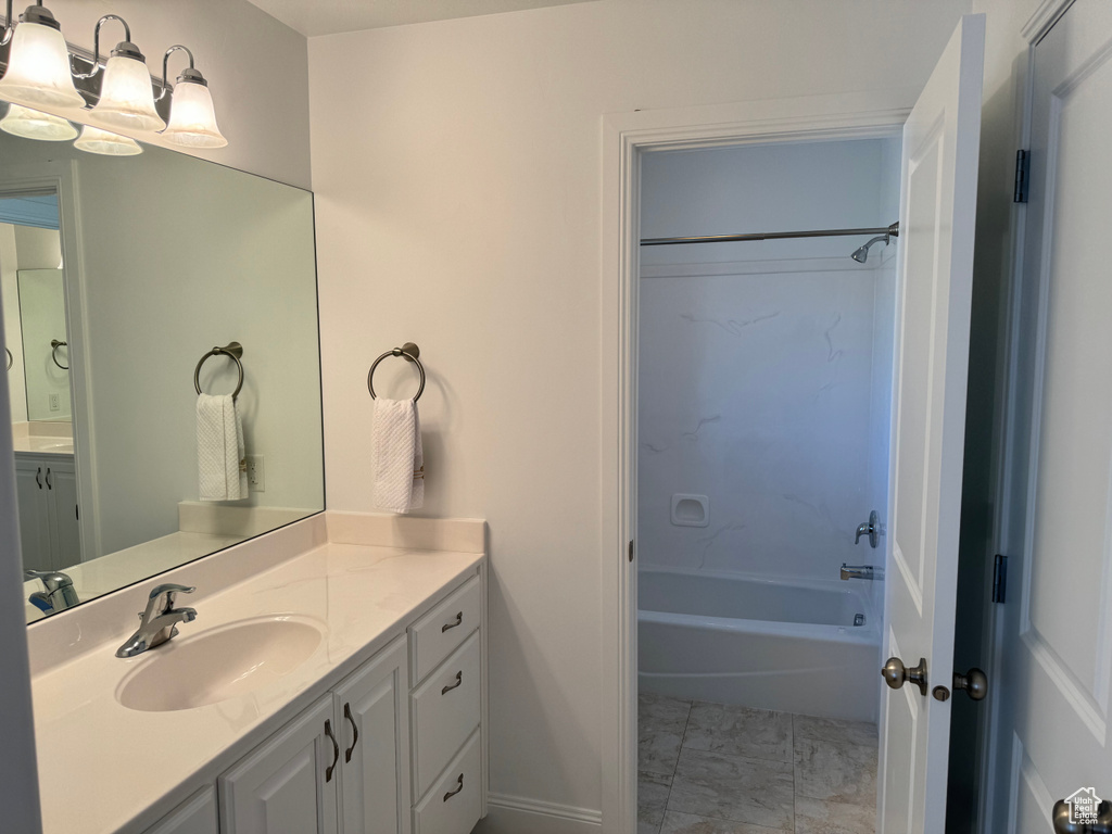 Bathroom with shower / tub combination, vanity, and tile floors