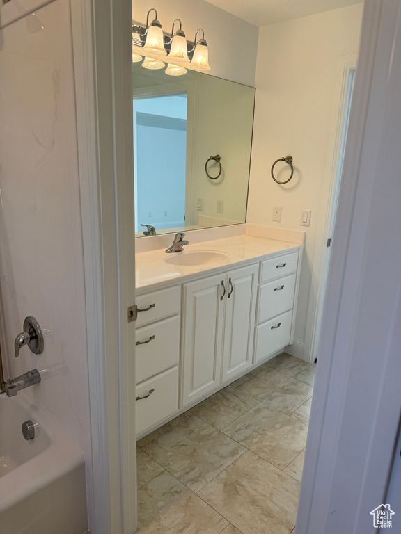 Bathroom featuring vanity, tile floors, and bathing tub / shower combination
