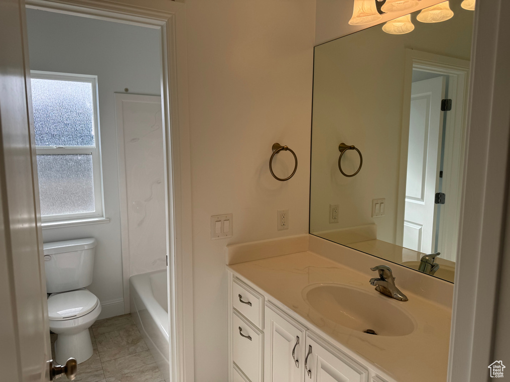 Full bathroom with a healthy amount of sunlight, toilet, tile flooring, and vanity