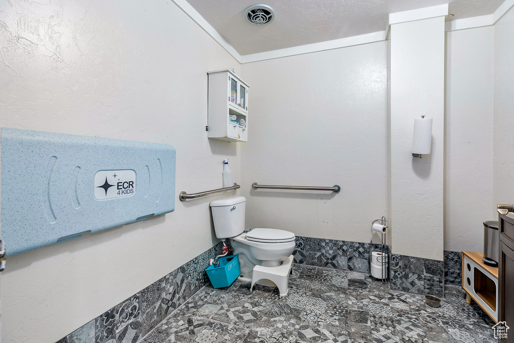 Bathroom with tile flooring, ornamental molding, vanity, and toilet