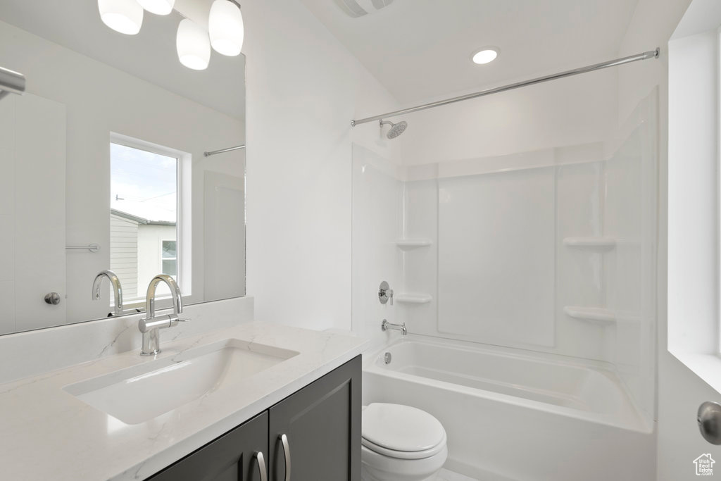 Full bathroom with shower / bath combination, vanity with extensive cabinet space, and toilet