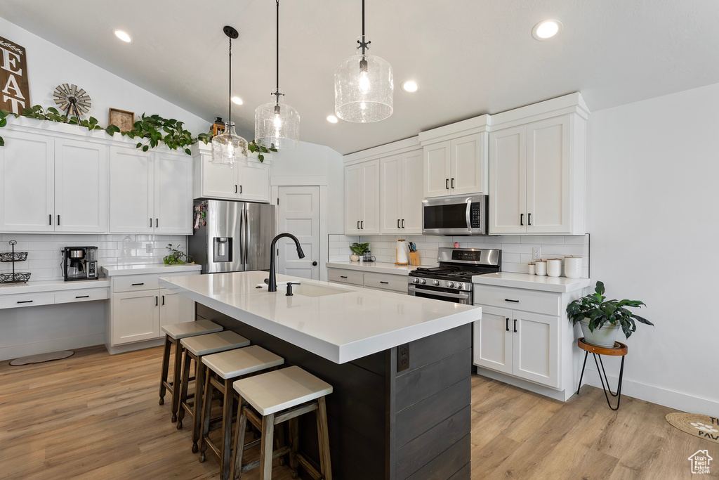 Kitchen with tasteful backsplash, stainless steel appliances, and light wood-type flooring