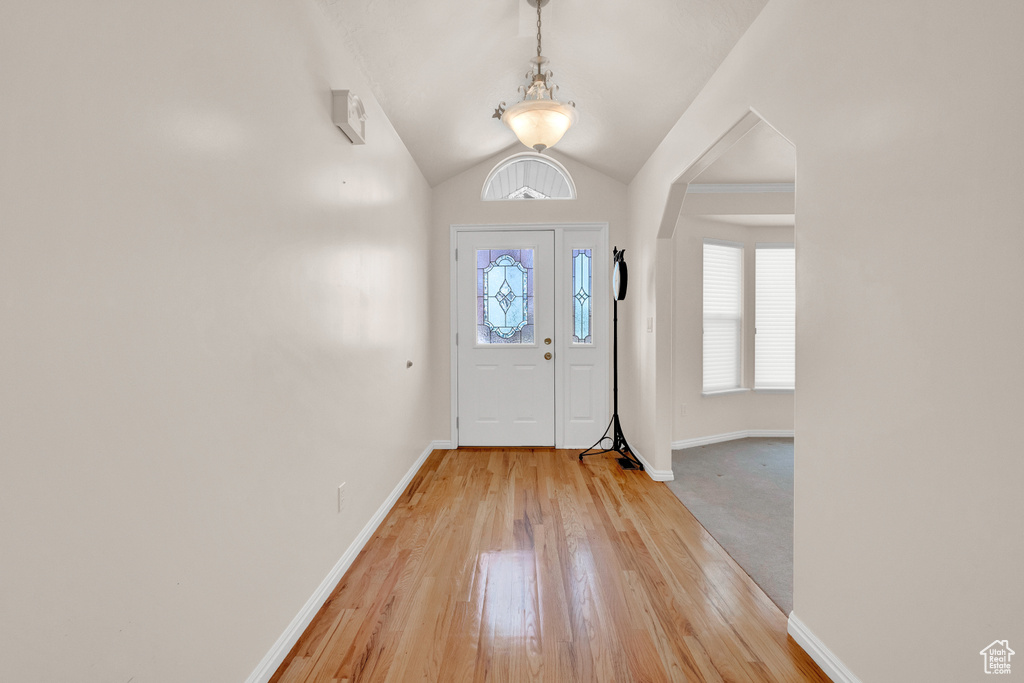 Foyer with carpet flooring and vaulted ceiling