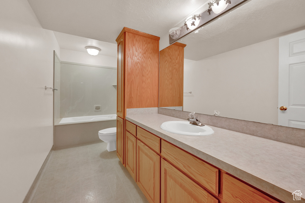 Full bathroom featuring shower / bath combination, oversized vanity, toilet, and tile flooring