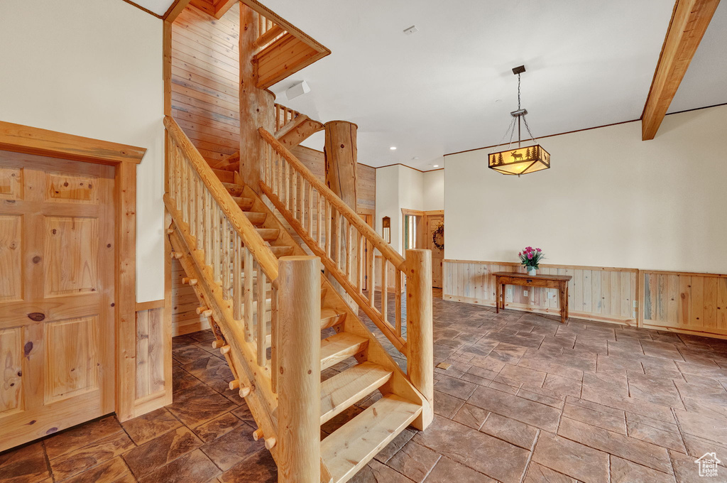 Stairway with beam ceiling and tile flooring