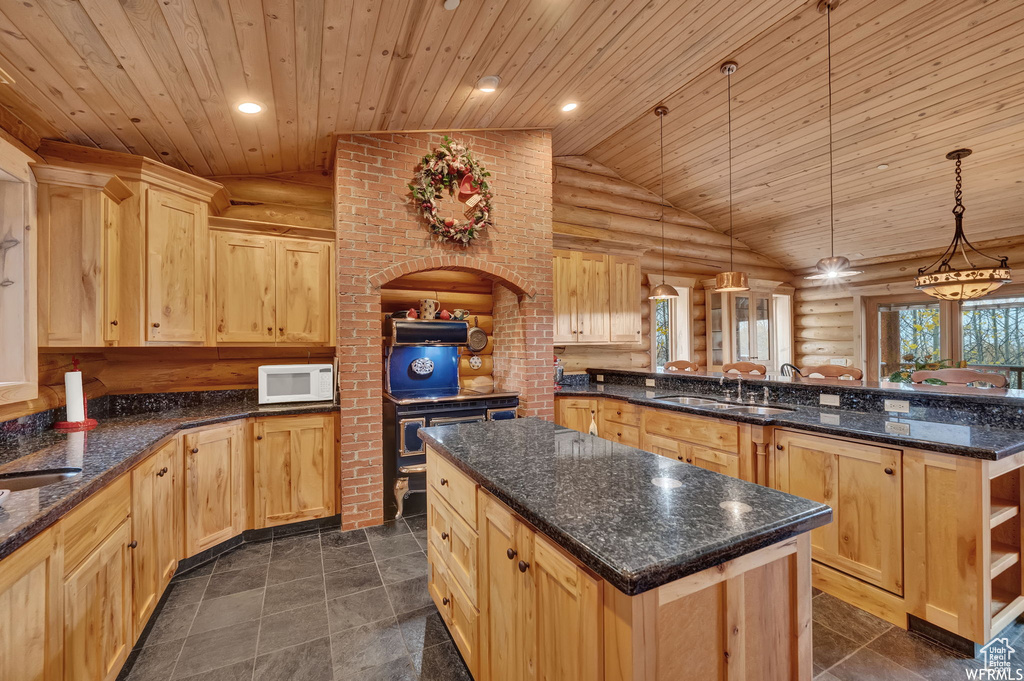 Kitchen with a kitchen island, vaulted ceiling, light brown cabinetry, sink, and log walls