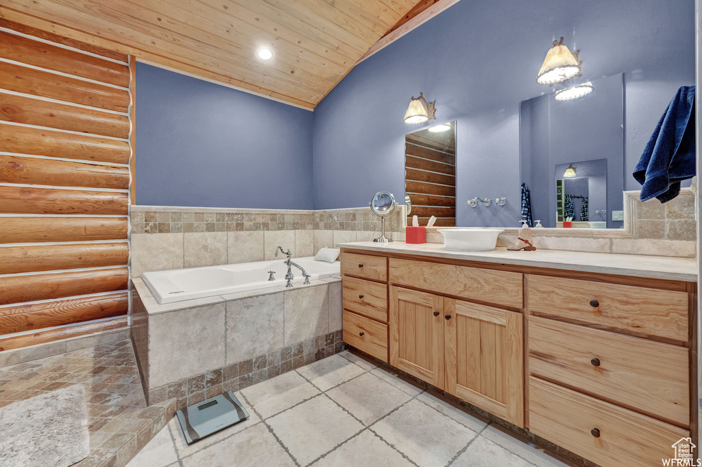 Bathroom with tile flooring, large vanity, tiled tub, wood ceiling, and vaulted ceiling