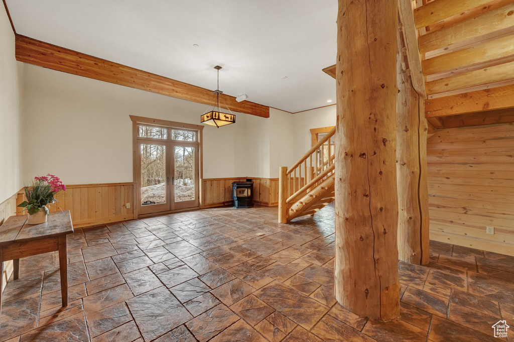 Foyer with french doors, a wood stove, and tile floors