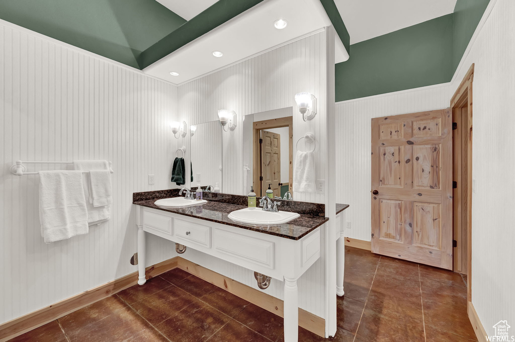 Bathroom featuring tile flooring, double vanity, and a towering ceiling