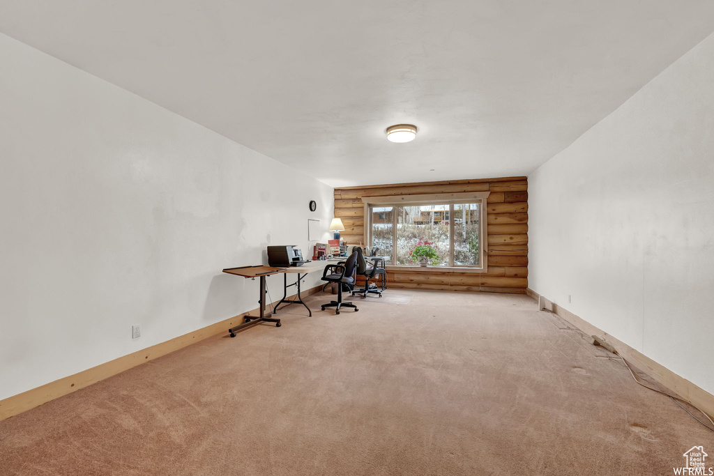 Carpeted office space with log walls