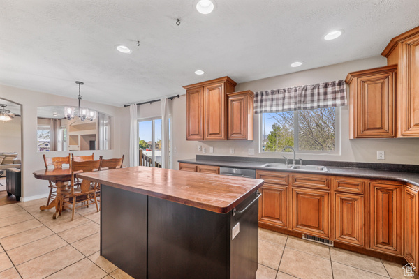 Kitchen featuring a healthy amount of sunlight, sink, pendant lighting, and light tile floors