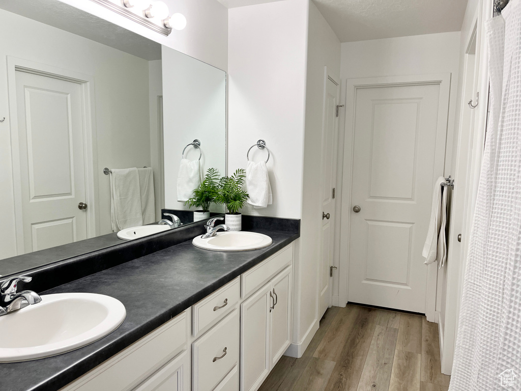 Bathroom featuring large vanity, hardwood / wood-style flooring, and double sink
