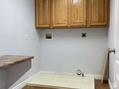 Washroom with hookup for an electric dryer, hookup for a washing machine, cabinets, dark tile flooring, and hookup for a gas dryer