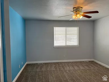 Carpeted spare room featuring ceiling fan and a textured ceiling