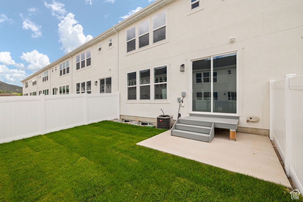 Back of property with stucco siding, entry steps, and a patio area