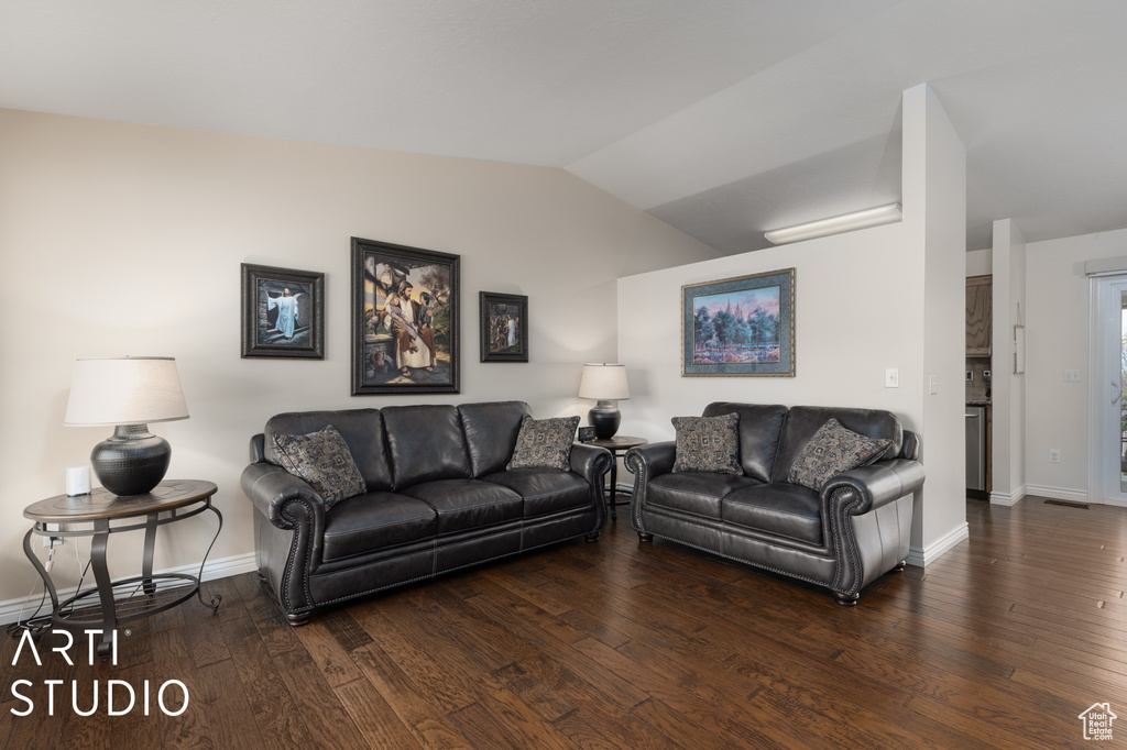 Living room featuring vaulted ceiling and dark hardwood / wood-style floors