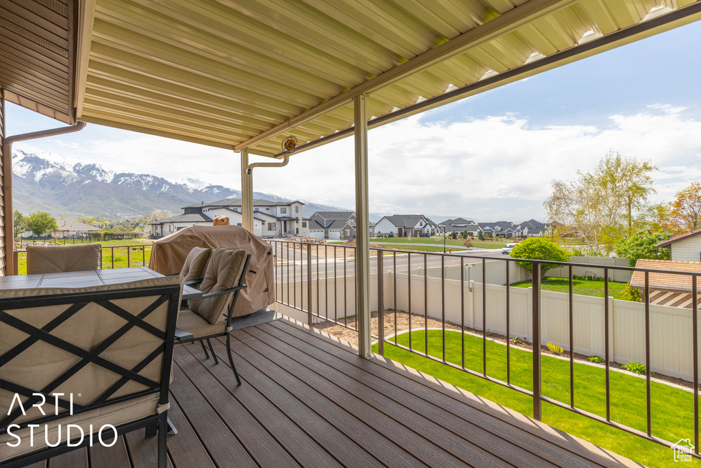 Wooden terrace featuring a mountain view, a yard, and grilling area