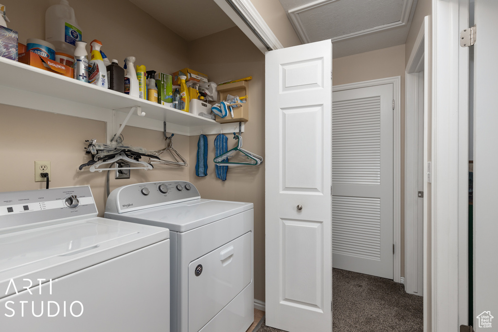 Laundry area featuring separate washer and dryer and dark carpet