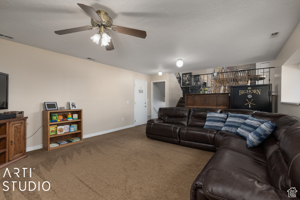 Living room featuring ceiling fan and carpet