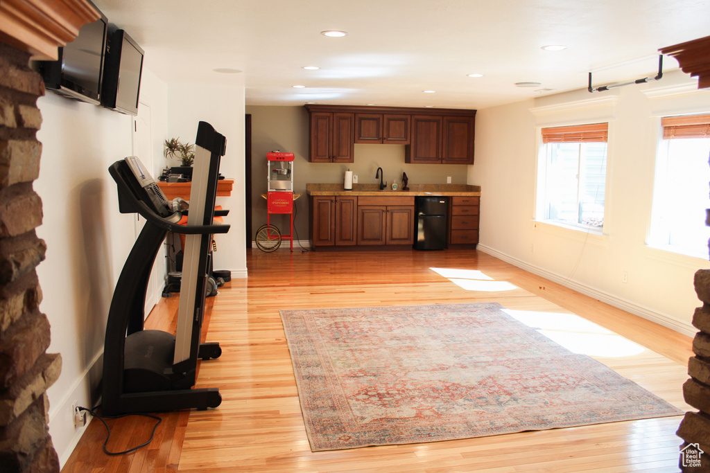 Workout area with sink and light wood-type flooring