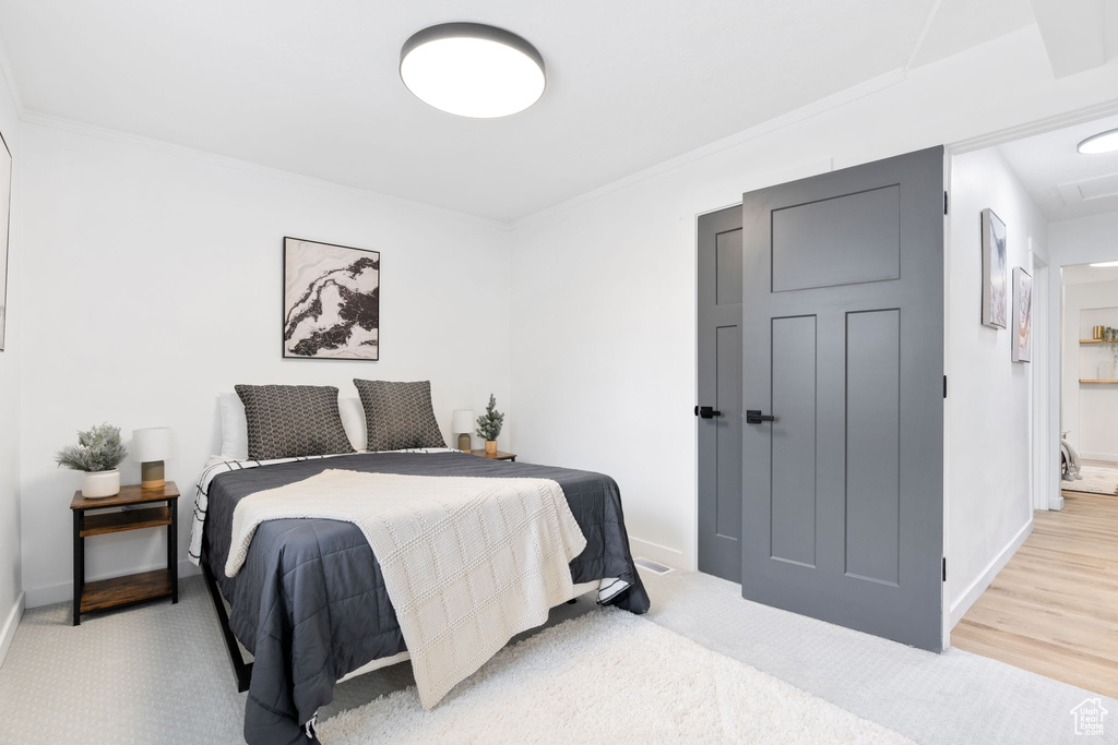 Carpeted bedroom with crown molding