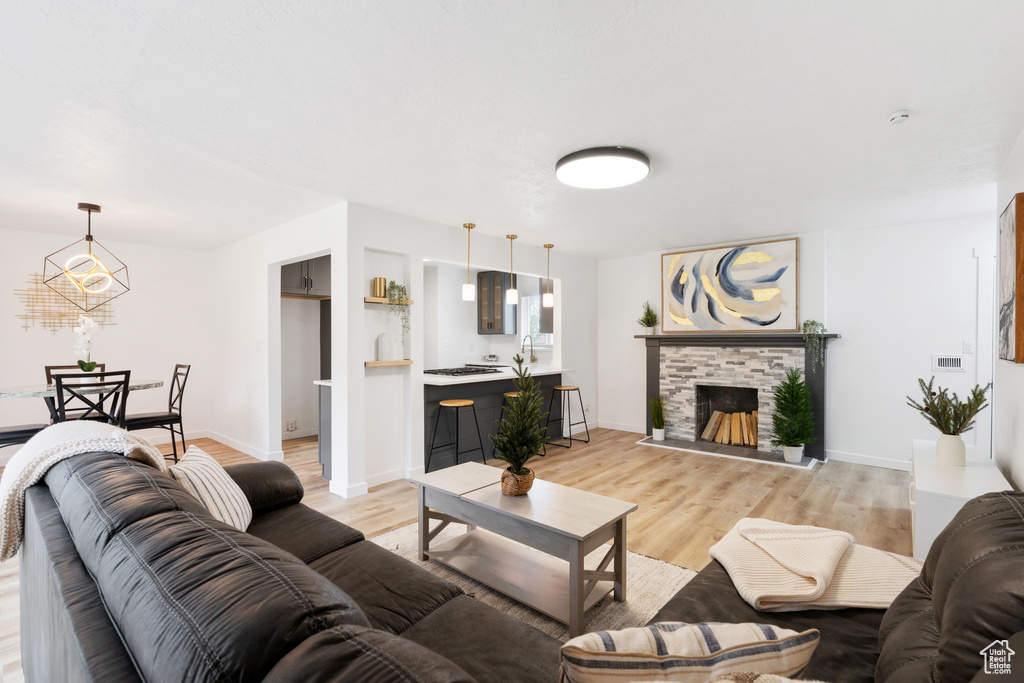 Living room featuring sink, light hardwood / wood-style flooring, and a fireplace