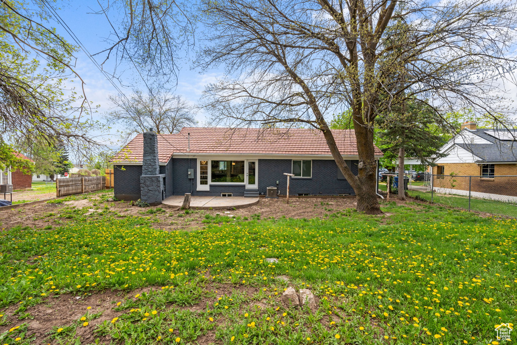 Rear view of house featuring a patio area and a lawn