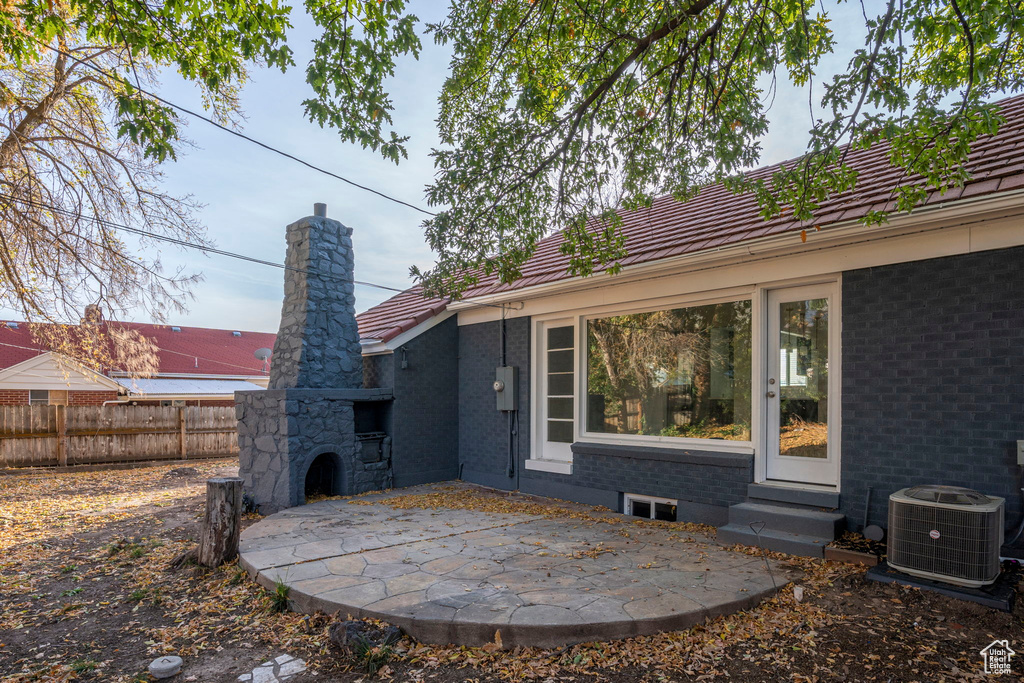 Rear view of property featuring central AC unit and a patio