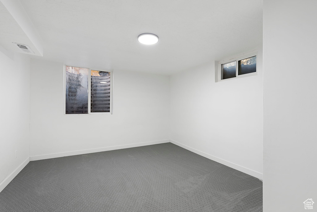 Unfurnished room featuring dark carpet