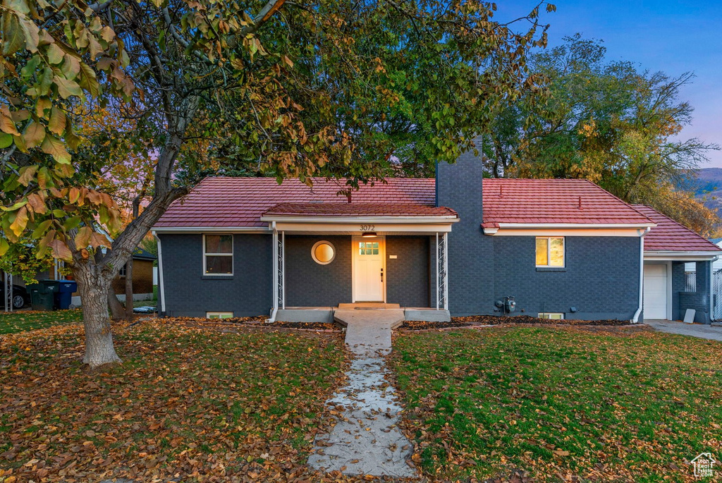 View of front facade with a garage and a lawn