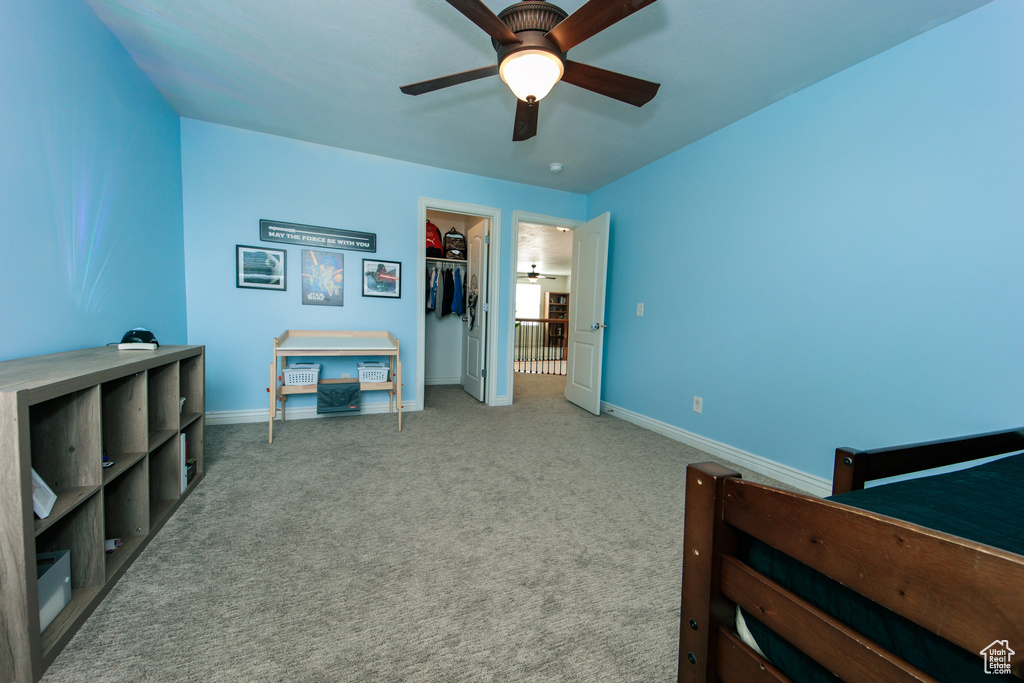 Bedroom featuring a closet, ceiling fan, a spacious closet, and carpet floors