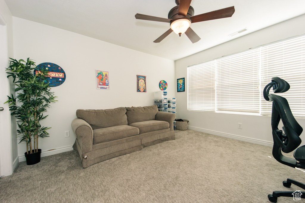 Living room featuring plenty of natural light, carpet floors, and ceiling fan
