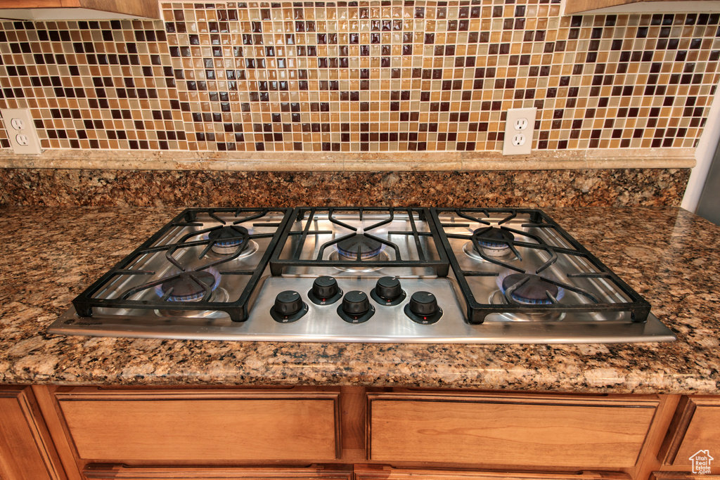 Interior details featuring backsplash and stainless steel gas stovetop
