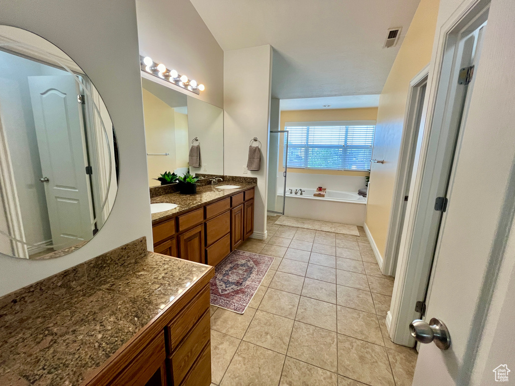 Bathroom featuring tile floors, dual bowl vanity, and a bathtub