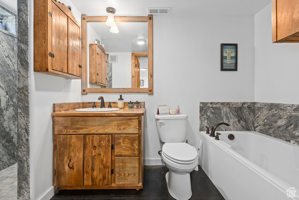 Bathroom featuring a bathtub, toilet, tile flooring, and large vanity