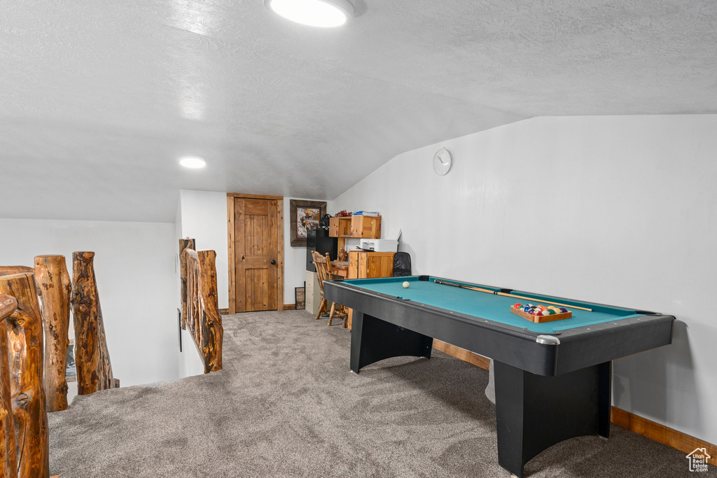 Game room with lofted ceiling, carpet floors, pool table, and a textured ceiling