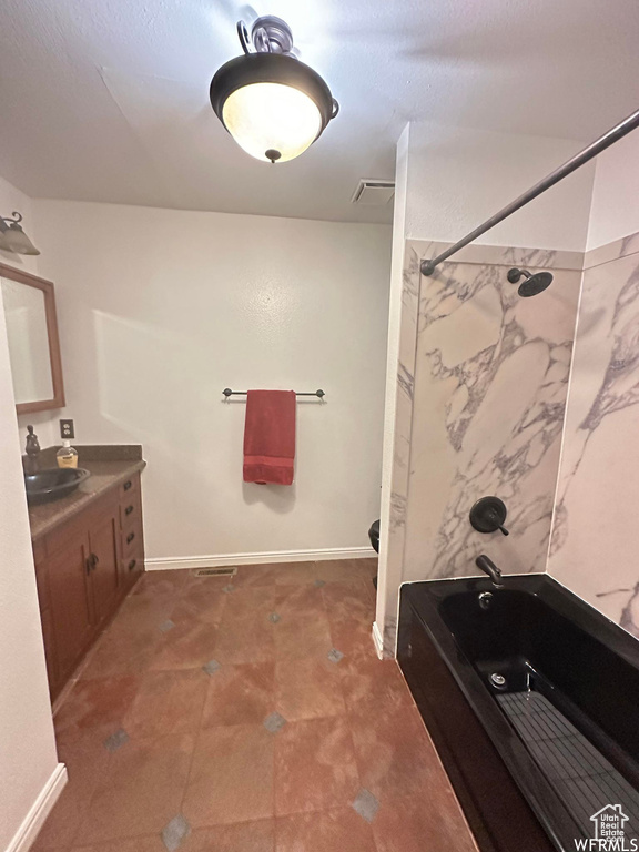 Bathroom featuring bathtub / shower combination, vanity, and tile floors