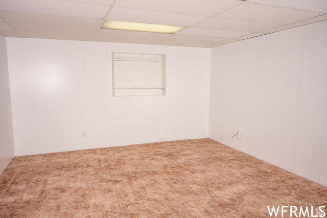 Unfurnished room featuring a paneled ceiling and carpet floors