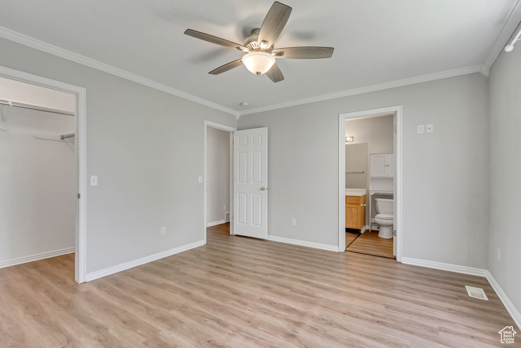 Unfurnished bedroom featuring a closet, light hardwood / wood-style flooring, ceiling fan, and ensuite bathroom