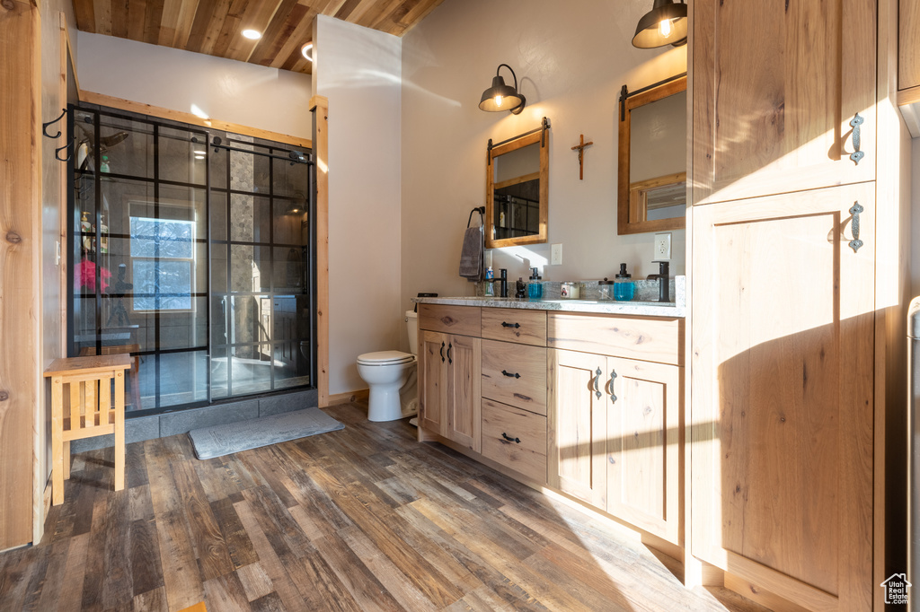 Bathroom with toilet, wood-type flooring, lofted ceiling, vanity, and wood ceiling