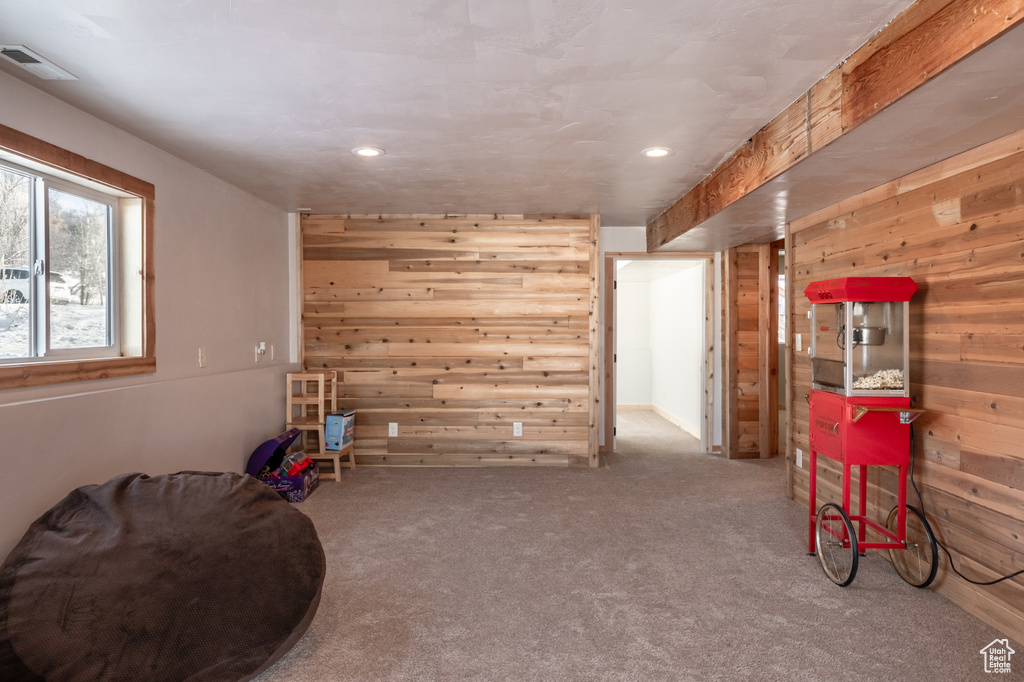 Miscellaneous room featuring wooden walls and carpet flooring