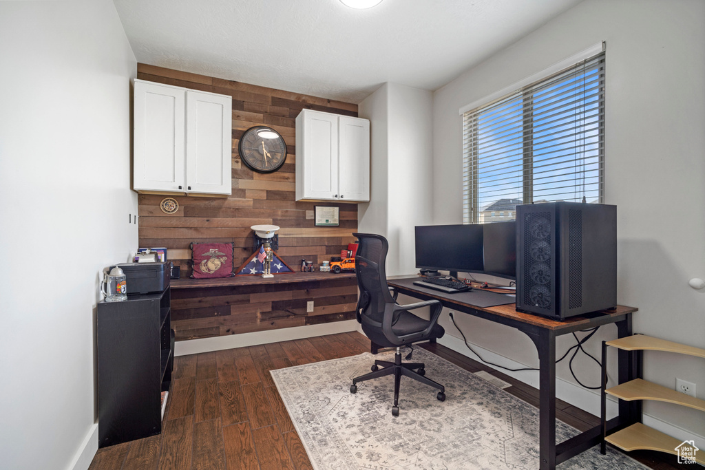 Office area featuring dark hardwood / wood-style floors and wood walls