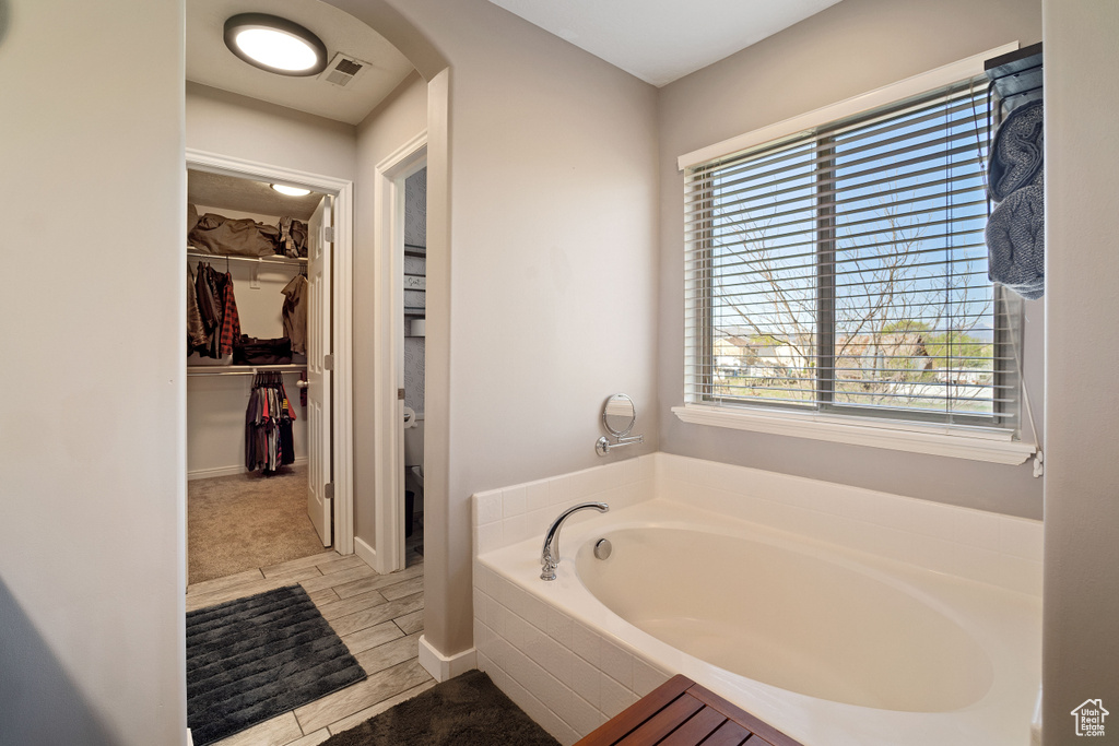 Bathroom with a bath to relax in and tile floors