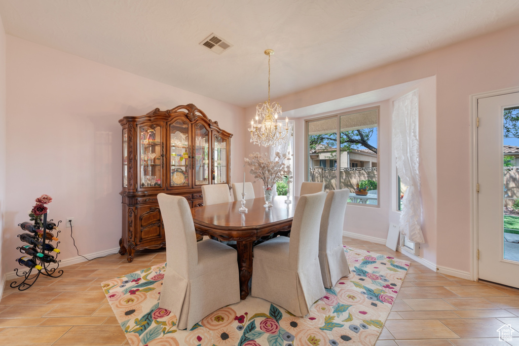 Dining space with a chandelier and light tile floors