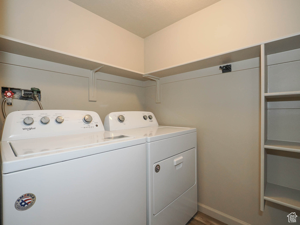 Laundry area featuring hardwood / wood-style flooring and washer and dryer